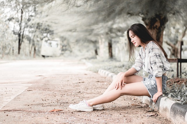 Девушка сидит на тротуаре girl